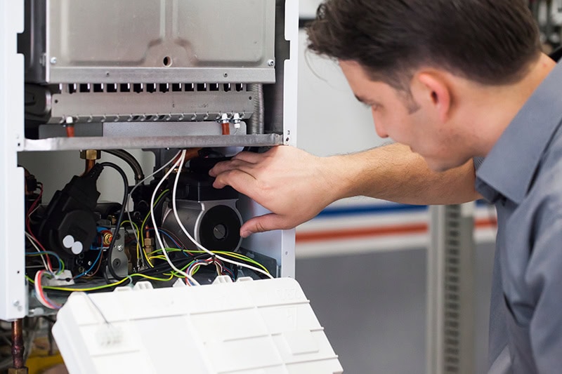 HVAC technicians performing maintenance on a heat pump.