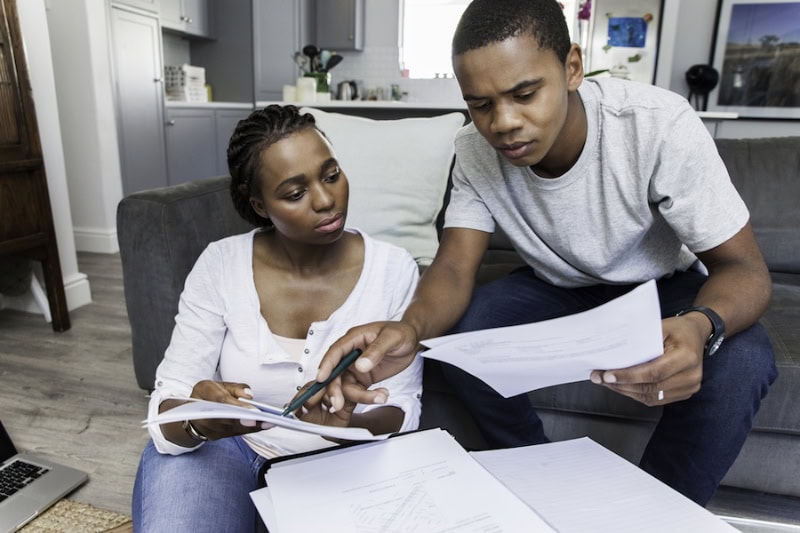 A Guide of Commonly Asked Questions About Refrigerants in 2025. Young african female and male couple at home reviewing questions.